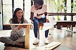 Women with instructions assembling furniture