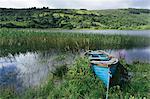 Blue wooden rowboat lying on the shore of Glenade Lake, Glenade, County Leitrim, Ireland.