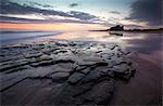 View towards Bamburgh Castle at sunrise from Bamburgh Beach, Bamburgh, Northumberland, England, United Kingdom, Europe