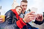 Young couple taking smartphone selfie in city