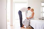 Romantic pregnant couple face to face in bedroom