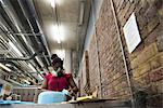 Woman in art studio wearing protective mask sanding object