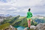 Rear view of female hiker on rocky edge looking out over Tannheim mountains, Tyrol, Austria