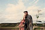 Portrait of happy pregnant mid adult couple in fields