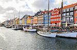 Colourful facades and typical boats along the canal and entertainment district of Nyhavn, Copenhagen, Denmark, Europe