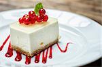 strawberry cheesecake slice on white plate with red writing