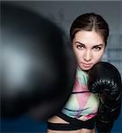 Young adult sexy boxing girl posing with gloves. Confident woman ready to fight