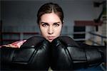 Young adult sexy boxing girl posing with gloves. Confident woman ready to fight