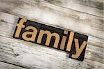 The word "family" written in wooden letterpress type on a white washed old wooden boards background.
