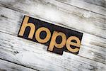 The word "hope" written in wooden letterpress type on a white washed old wooden boards background.