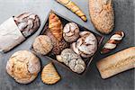 A basket full of delicious freshly baked bread on wooden background