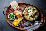 Seafood fish soup in clay bowls served with cold white wine, copy space, top view