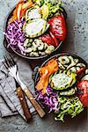 Budha bowl. Raw vegetables with beans, grilled avocado and bell pepper on slate background