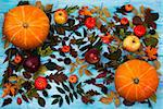 Thanksgiving  greeting with pumpkin, apples and autumn leaves on blue wooden table. Fall background with vegetables, cones and fruits
