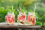 Watermelon water in glass jars in the open air. Concept for healthy eating and nutrition.