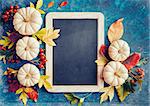 Autumn background with festive decoration and vintage chalkboard for your message.