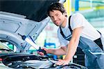 Auto mechanic working in car service workshop working