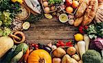Different foods on a wooden background wiht copyspace. Various fruits and vegetables, fish, bread and eggs.