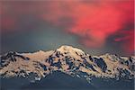 Beautiful sunset over the snowy mountain peak. Nature landscape scene. Dramatic overcast red sky. Holidays, travel, sport, recreation. Main Caucasian ridge, Svaneti, Georgia. Retro toning filter