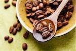 Coffee beans in wooden spoon close-up. Selective focus