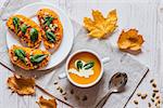 Pumpkin cream soup. Vegan healthy food. Breakfast or brunch on white wooden background.