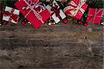 Christmas gift giving concept - christmas presents in red and white boxes with ribbons on wooden table, flat lay with copy space