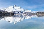 Snowy peaks reflected in the clear water of Lake Sils, Maloja, Canton of Graubunden, Engadine, Switzerland, Europe