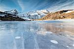 Blue sky on the frozen Lej Nair surrounded by snowy peaks, Bernina Pass, Canton of Graubunden, Engadine, Switzerland, Europe