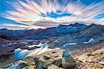 Clouds at dawn are reflected in Lai Ghiacciato framed by peaks, Val Ursaregls, Chiavenna Valley, Valtellina, Lombardy, Italy, Europe