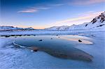 Pink clouds at dawn on the alpine Lake, Piz Umbrail surrounded by snowy peaks, Braulio Valley, Valtellina, Lombardy, Italy, Europe