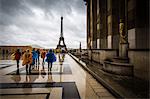 Heading towards the Eiffel Tower, tourists brave the rain in colourful ponchos at the Palais De Chaillot, Paris, France, Europe