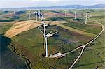 High angle view of rolling landscape with fields and wind turbines.