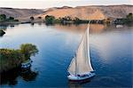 High angle view of sailboat on a lake, sand hills in the distance.