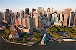 Cityscape of Lower Manhattan, New York, USA, at dusk, with skyscrapers lining Hudson River.