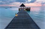 Wooden jetty and boat at sunset, Coco Palm Resort, Dhuni Kolhu, Baa Atoll, Republic of Maldives, Indian Ocean, Asia