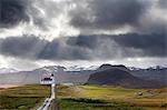 Ingjaldsholskirkja set against mountains on a dramatic stormy day, near Rif, Snaefellsnes Peninsula, Iceland, Polar Regions