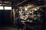 Mechanic repairing vintage motorcycle wheel at workshop bench