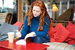 Woman at coffee shop writing in notepad