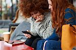 Friends at coffee shop looking at mobile phone