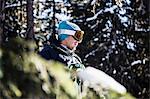 Portrait of skier beside trees, looking at view