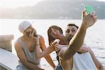 Three young hipster friends taking selfie on waterfront, Lake Como, Lombardy, Italy