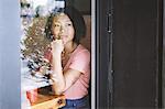 Woman gazing through cafe window, Shanghai French Concession, Shanghai, China