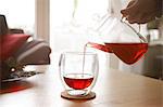 Woman pouring red tea into glass