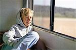 Boy sitting in campervan looking out of window, Polonio, Rocha, Uruguay, South America