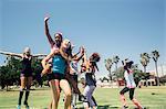 Girls and teenage schoolgirls jumping and running on school sports field