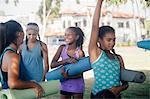 Schoolgirls preparing for yoga practice on school sports field