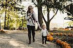 Mother walking with young daughter in rural setting