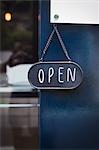 Close up of open sign on glass door to a bakery.