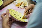 Close up of person working in a Japanese porcelain workshop, applying yellow glaze to a white plate.