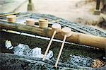 Close up of bamboo water hand washing basins at Shinto Sakurai Shrine, Fukuoka, Japan.